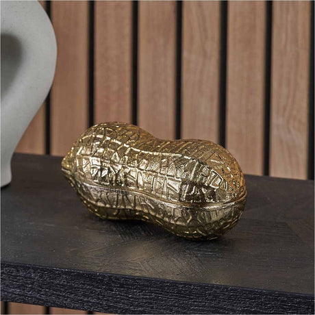 Gold Aluminium Peanut Lidded Trinket Bowl, 22cm, textured peanut-shaped design, shown on a dark wood shelf with a wooden slat wall background.
