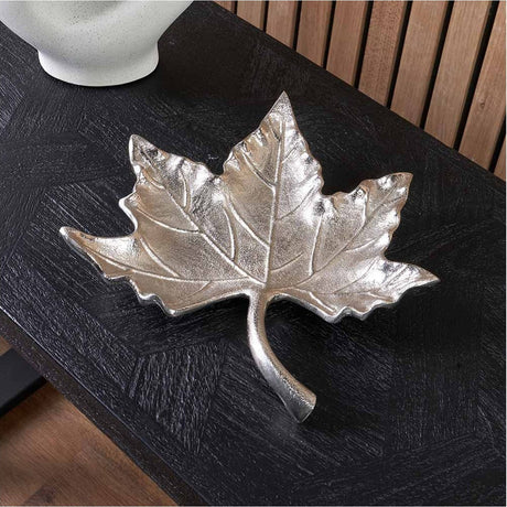 Silver Aluminium Leaf Bowl, 28cm, shaped like a maple leaf with embossed veins, displayed on a dark wood table beside a wooden slatted wall.