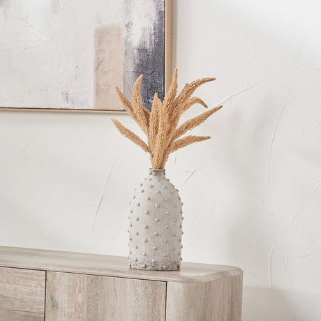 Kali Textured Dot Light Grey Stoneware Vase, 31cm, with a bobble-textured tapered body holding dried pampas grass stems, styled on a wooden sideboard against a white wall.