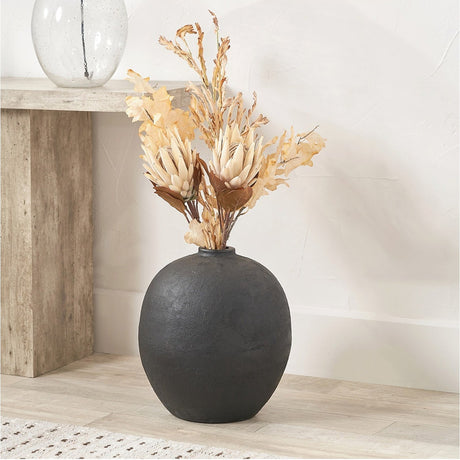 Round matt black fibrestone decorative vase, 41cm, with dried floral stems, styled beside a wooden console table against a pale wall.