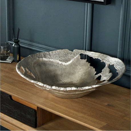Antique Silver Cast Aluminium Decorative Bowl, 46cm, with a jagged torn-edge design, shown on a wooden sideboard against a dark grey panelled wall.