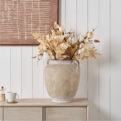 Textured natural fibrestone vase, 41cm, with side handles, filled with dried cream floral stems, styled on a wooden sideboard against white panelled wall.
