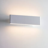 Endon Ambrose matt white LED wall light, compact rectangular fitting casting warm up-and-down glow on a pale wall.