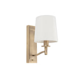 Endon Castwell wall light in matt antique brass with a single curved arm and vintage white faux-silk tapered shade, shown on a plain white background.