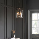 Endon Caldbury 4 light pendant in nickel with clear glass panels and E14 candle lamps, hung from a chain in a dark panelled hallway near a window.