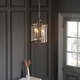 Endon Caldbury 4 light pendant in nickel with clear glass panels and E14 candle lamps, hanging from a chain against a dark panelled hallway wall.