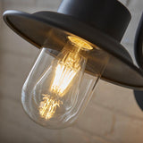 Endon Bevfield PIR outdoor wall light in textured black, close-up of the fisherman-style lantern with clear glass diffuser and lit filament bulb.