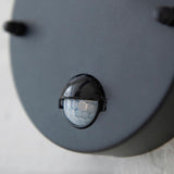 Close-up of the built-in PIR sensor on Endon's Bevfield outdoor wall light, showing a black domed motion detector on the textured black housing.
