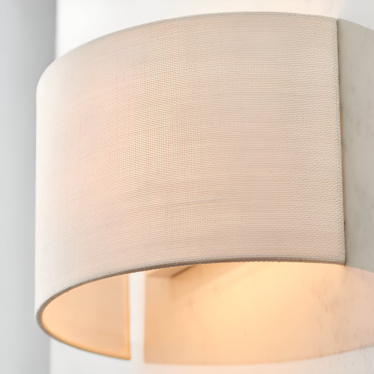 Close-up of the Endon Castmere wall light in white, showing its semi-circular linen shade on a steel frame casting a soft downward glow.