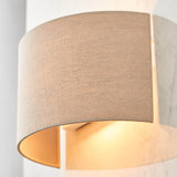 Endon Castmere semi-circular wall light in natural linen on a steel frame, illuminated to cast a soft downward glow against a pale wall.