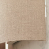 Close-up of the Endon Castmere wall light in natural linen, showing the semi-circular fabric shade and steel frame mounted on a pale wall.