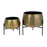 Libra Interiors Etched Brass Set of 2 Standing Planters, round iron pots with cross-hatched brass finish on slim black four-leg frames, on a white background.