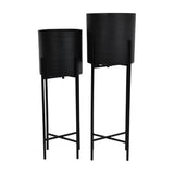 Libra Interiors Etched Iron Set of 2 Floor Standing Planters in matt black, cylindrical pots with cross hatch texture on slim four leg stands.