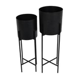 Libra Interiors Etched Iron set of two floor standing planters in matt black, cylindrical pots with cross hatch texture on slim four leg stands.