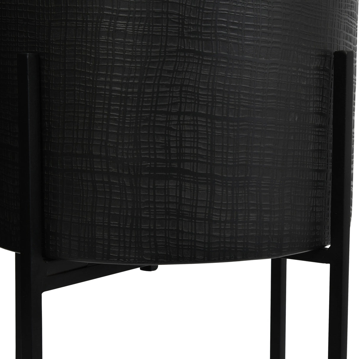 Close-up of Libra Interiors Etched Iron Floor Standing Planter in matt black, showing the cross hatch textured iron pot held in a slim four leg stand.