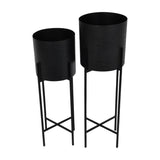 Libra Interiors Etched Iron Set of 2 Floor Standing Planters in matt black, cylindrical pots with cross hatch texture on slim four leg stands.