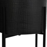 Close-up of Libra Interiors Etched Iron floor standing planter in matt black, showing the cross hatch textured cylindrical pot on slim four leg metal stand.