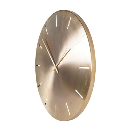 Libra Interiors Brushed Gold Iron Round Wall Clock shown at an angle with raised hour markers and slim matching hands on a warm gold metal face.