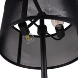 Close-up of Libra Interiors Mesh Shade Iron Floor Lamp in black, showing two exposed filament bulbs inside the perforated drum shade and central stem.