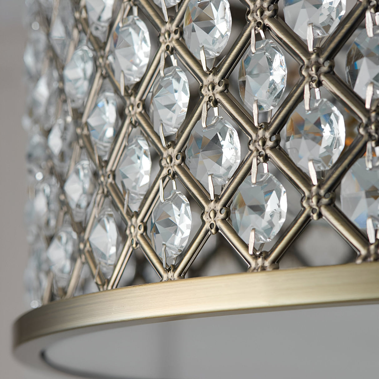 Close-up of Endon Prescott 3 Light Crystal Flush Ceiling Light showing the antique brass lattice frame set with faceted crystals above the curved rim.