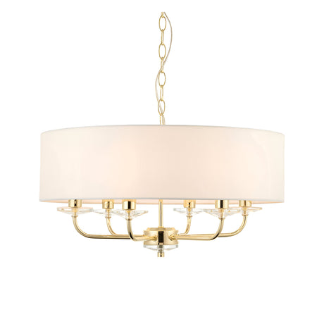 Endon Castdon 6 light pendant in brass with a large white faux silk drum shade, crystal bobeche details, and chain suspension on a white background.