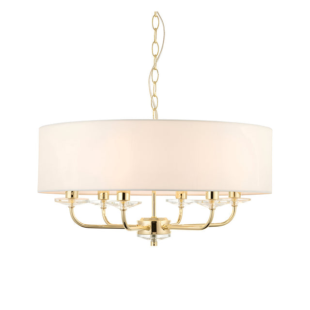 Endon Castdon 6 light pendant in brass with a large white faux silk drum shade, crystal bobeche details, and chain suspension on a white background.