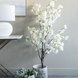 Libra Interiors Potted White Blossom Cherry artificial tree with slim brown branches and green leaves, styled beside a console table with lamp.