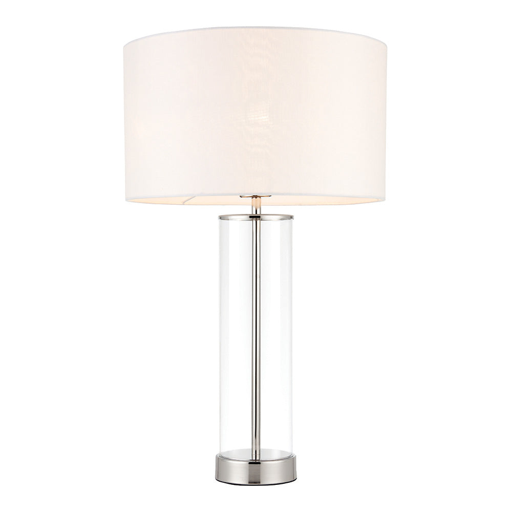 Endon Caldley table lamp with clear cylindrical glass base, bright nickel fittings and vintage white faux silk drum shade, on a plain white background.