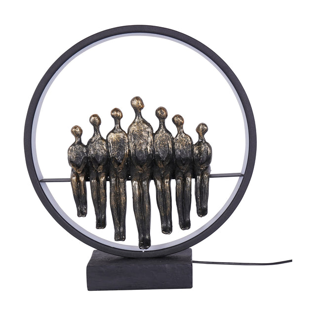 Libra Interiors Bronze Family Circle LED lighting accessory with seven antique bronze resin figures seated within a black metal ring on a plinth base.