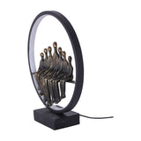 Libra Interiors Bronze Family Circle LED lighting accessory with seven seated resin figures in antique bronze inside a black metal ring on a solid base.