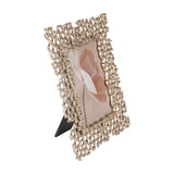 Libra Interiors Openwork Cast Aluminium Photo Frame in gold with honeycomb border, easel back, and portrait floral print, on a white background.