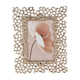 Libra Interiors Openwork Cast Aluminium Photo Frame in gold with a honeycomb-inspired border, holding a portrait floral print on a white background.