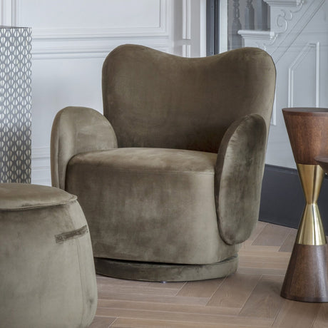 Libra Interiors Bingham green velvet swivel accent armchair with curved back and padded arms, shown with matching pouffe in a panelled living room.