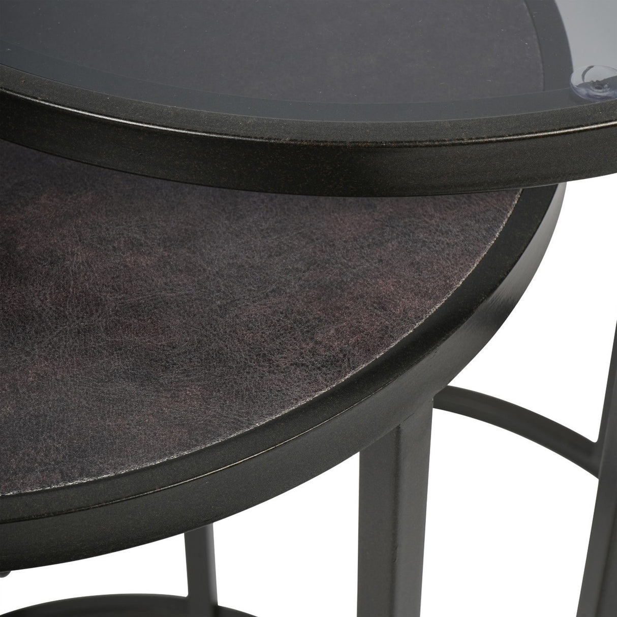 Close-up of Libra Interiors Slate Effect Iron Nesting Side Tables in black, showing the tinted glass top over the textured slate-effect lower table.