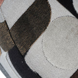 Close-up of Libra Interiors Patterned Velvet Swivel Armchair showing slub velvet upholstery with geometric patches in cream, espresso, black and blush tones.