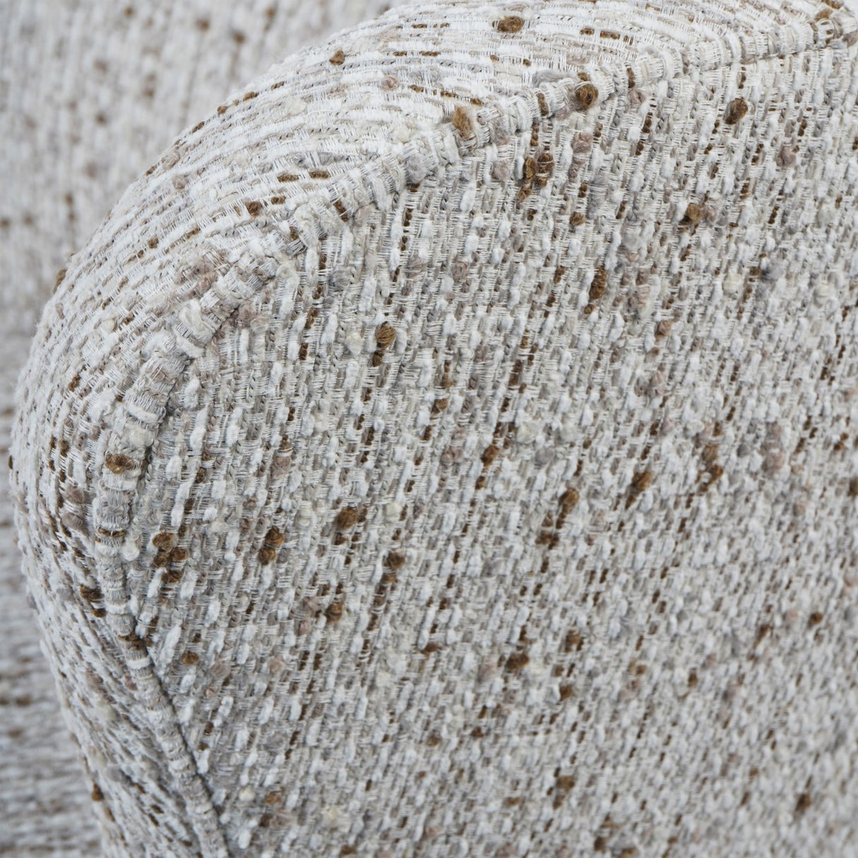 Close-up of Libra Interiors Textured Swivel Fabric Armchair in Natural, showing the ivory, sand and almond flecked slub weave over a rounded padded frame.