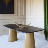 Libra Interiors Black Marble & Brass Twin-Pedestal Dining Table with softened rectangular top on two brass cone bases, styled with a gilt twig bowl.
