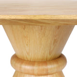 Close-up of Libra Interiors Round Oak Veneer Pedestal Dining Table in natural brown, showing the grained top edge and sculptural cone-shaped wooden base.