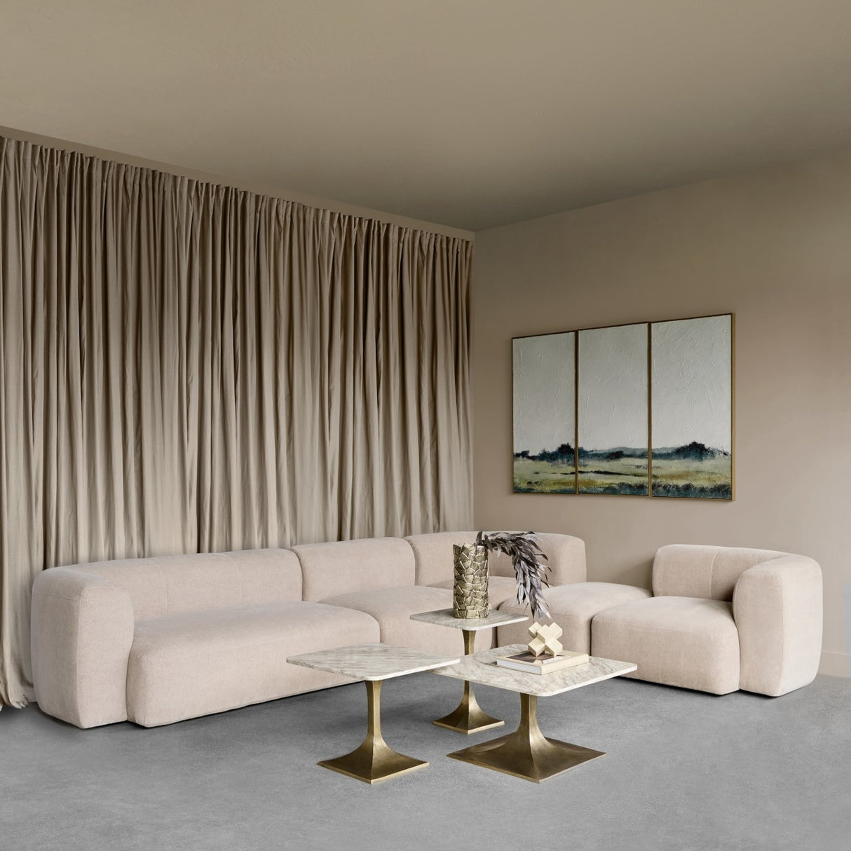 Libra Interiors Chenille 5-Piece Modular Sofa in beige styled in a contemporary living room with taupe curtains, marble side tables and landscape triptych.