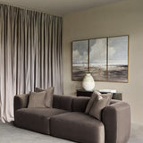 Libra Interiors brown velvet curved two-seater modular sofa with plush cushions in a neutral living room with taupe curtains and triptych wall art.