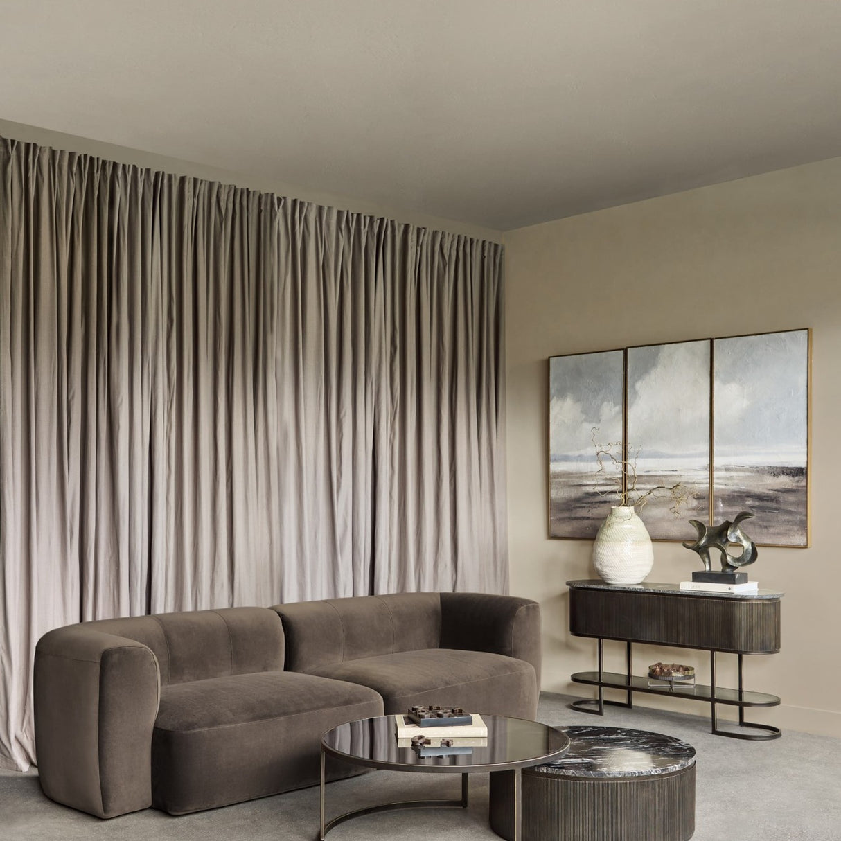Libra Interiors Velvet Curved 2-Seater Modular Sofa in brown, styled in a living room with floor-length drapes, round coffee tables and a fluted console.