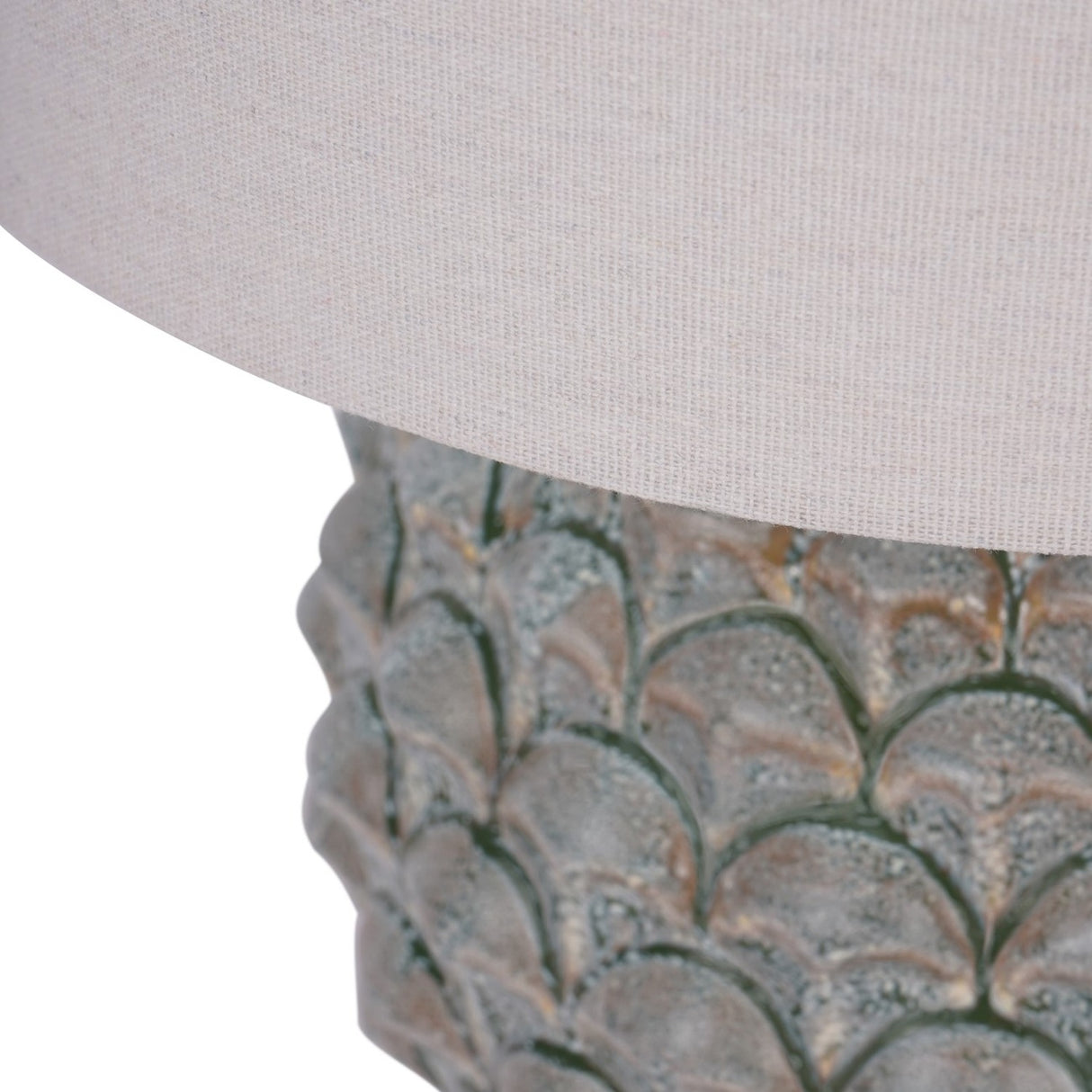 Close-up of Libra Interiors Glazed Ceramic Artichoke Table Lamp in green, showing the layered petal-moulded base with mottled glaze beneath a pale drum shade.