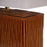 Close-up of the Libra Interiors Ridged Ceramic Rectangular Table Lamp base in glazed terracotta brown, with vertical ridges and a brass-toned neck.