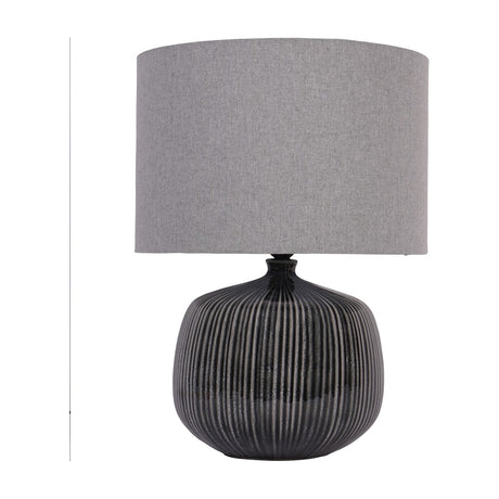 Libra Interiors Ribbed Ceramic Table Lamp in charcoal with a rounded vertically ribbed glazed base and grey fabric drum shade on a white background.