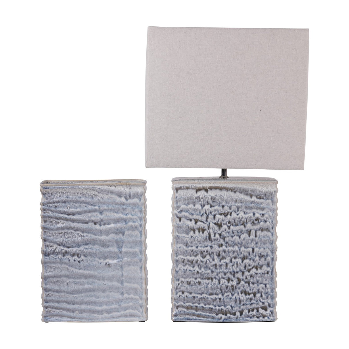 Libra Interiors Rippled Ceramic Rectangular Vase in blue reactive glaze shown beside a linen-shaded table lamp with a matching textured ceramic base.