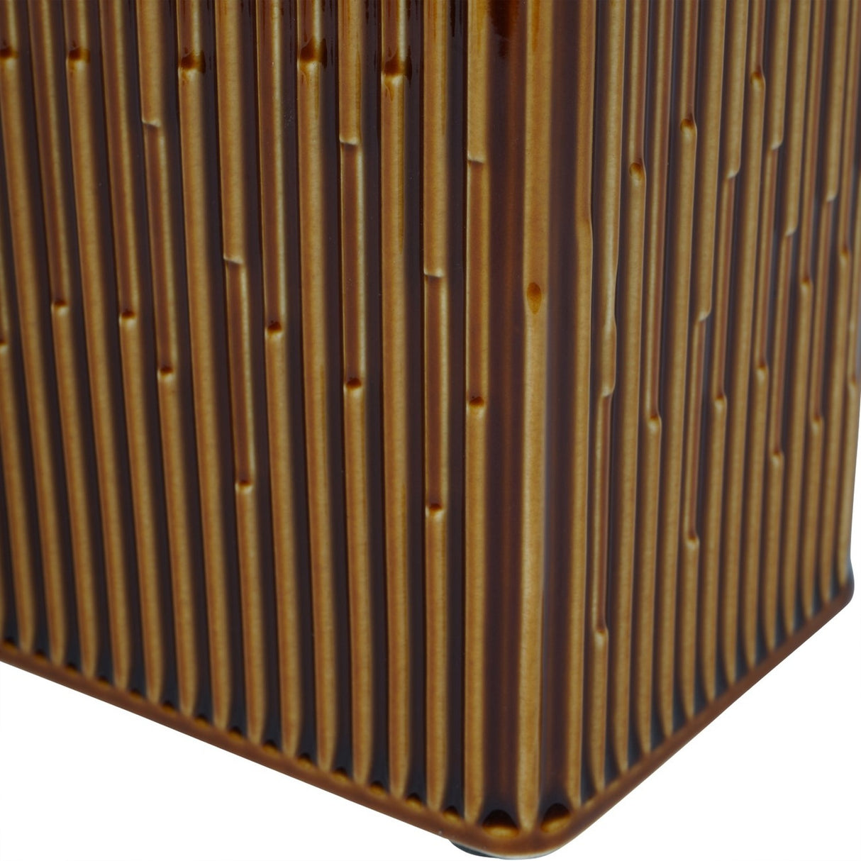 Close-up of the Libra Interiors ribbed ceramic vase showing the glossy terracotta-brown glaze and fine vertical ridges along its rectangular corner.