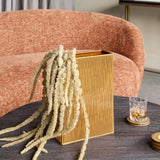 Libra Interiors Ribbed Ceramic Vase in terracotta brown, tall rectangular form with dried grasses, styled on a dark round table beside a pink sofa.