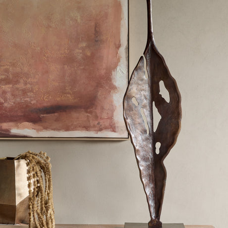 Libra Interiors Twisting Leaf aluminium sculpture in bronze with tall tapering form and organic cut-outs, displayed beside a pink abstract artwork.
