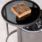 Libra Interiors mango wood solitaire game with brass ball pieces set in a square wooden tray, displayed on a round smoked glass side table.