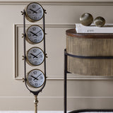 Libra Interiors Brushed Brass Four-Dial World City Floor Clock with vertical New York, London, Hong Kong and Sydney dials beside a fluted console.